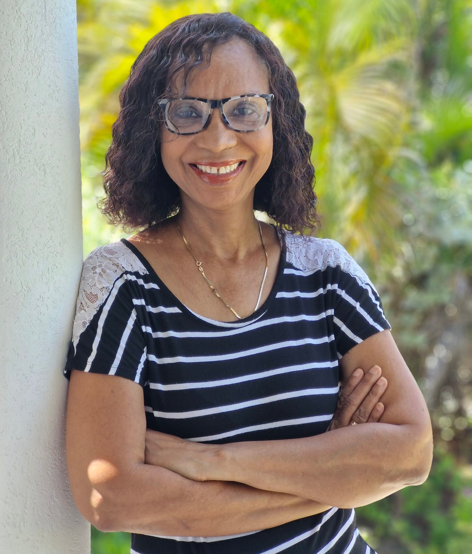 woman (Andrea Belle) smiling and leaning on a wall